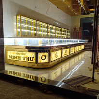 Mẫu tủ vàng inox chữ L bo góc ốp PVC vân đá xuyên sáng 